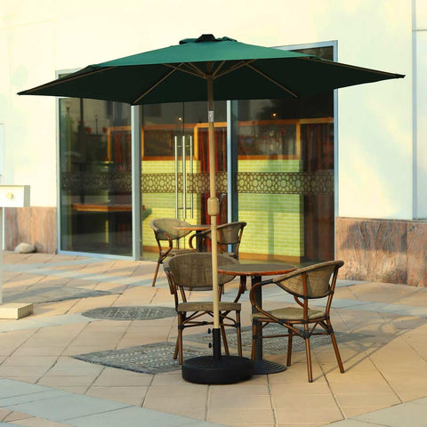 Green outdoor umbrella providing shade in a garden setting